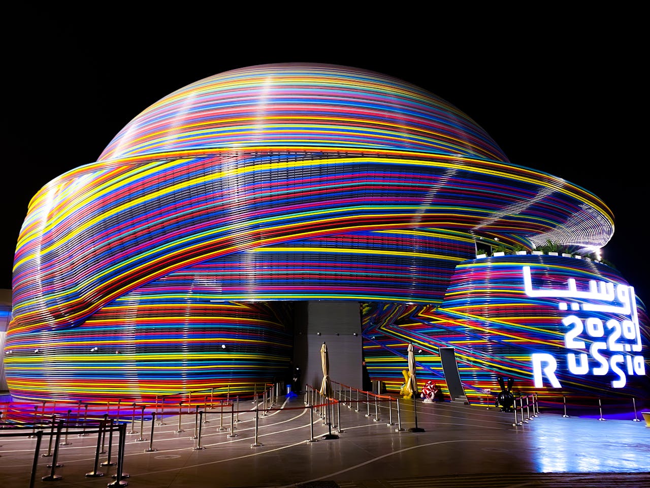 Services Vibrant neon-lit Russian Pavilion at Dubai Expo 2020, showcasing modern architecture.