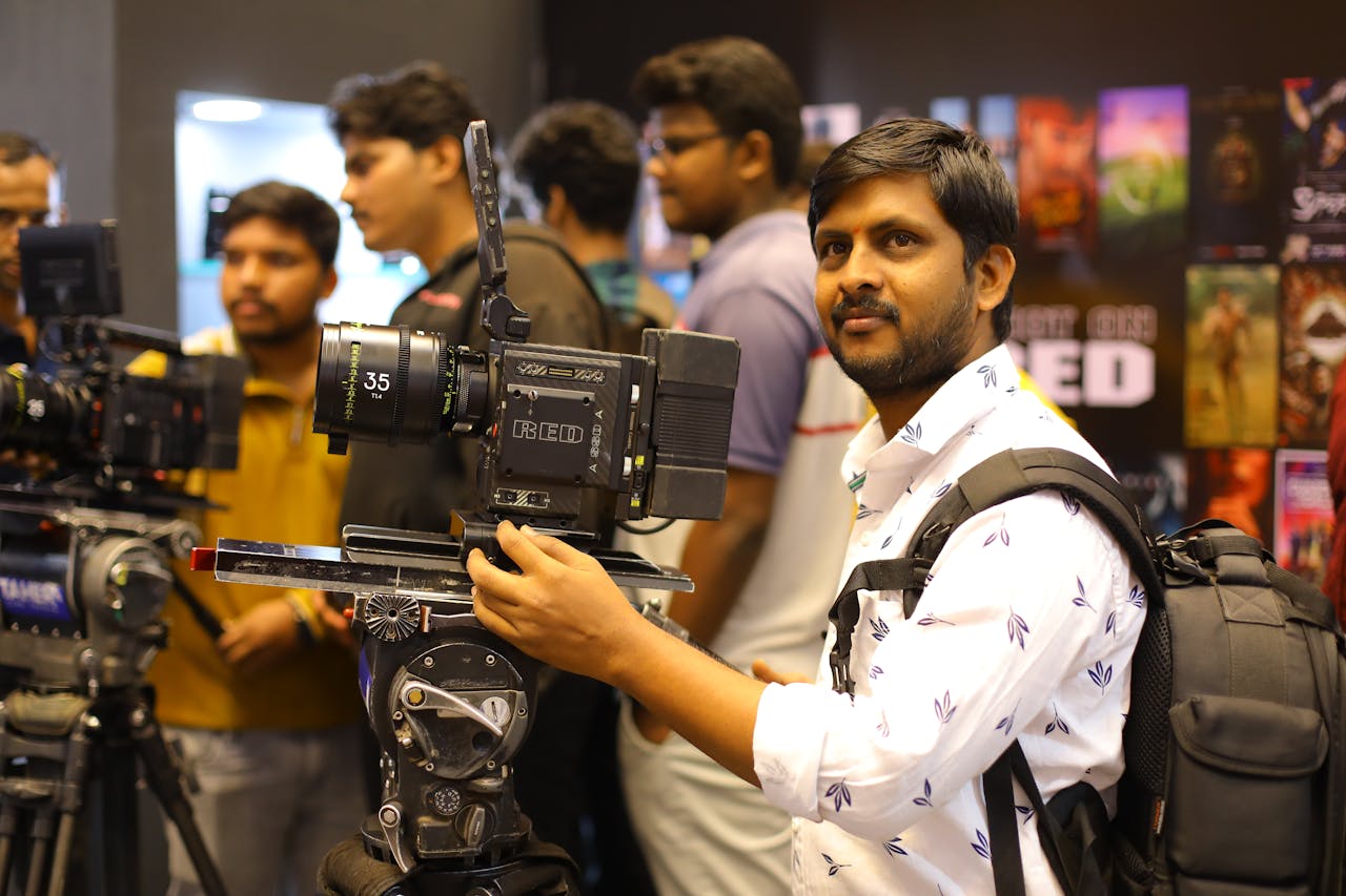 Home Photographer handling camera equipment at a film expo in Hyderabad.